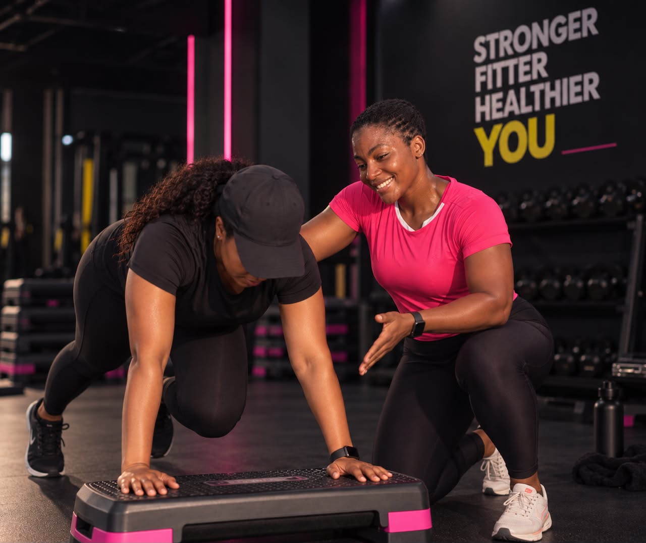 Personal trainer coaching a client through a step-board exercise